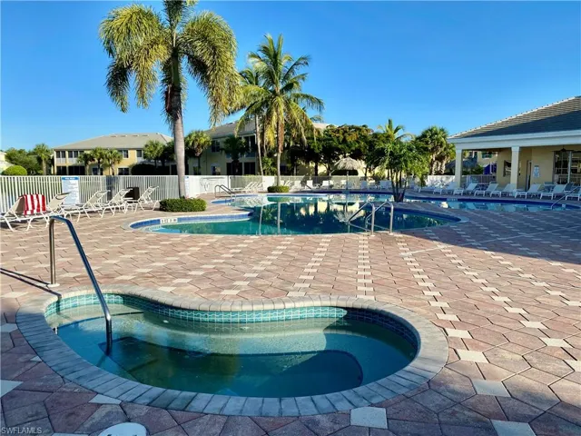 View of swimming pool featuring a community hot tub and a patio area