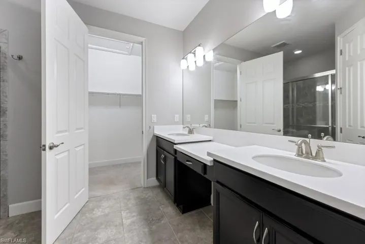 Bathroom featuring tile patterned floors, an enclosed shower, and vanity