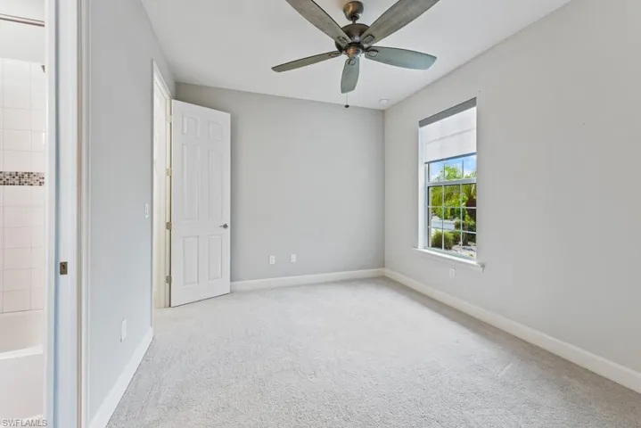 Unfurnished bedroom with ceiling fan and light carpet