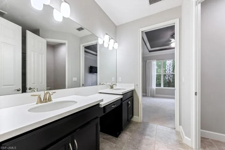 Bathroom featuring tile patterned floors, ceiling fan, crown molding, and vanity