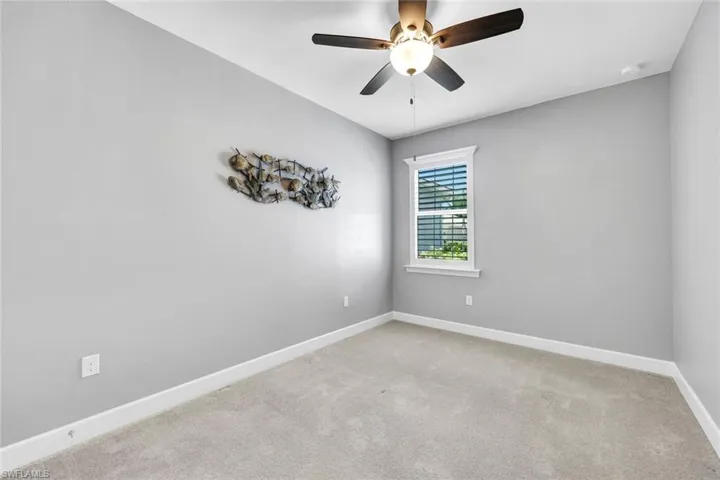 Spare room featuring light colored carpet and ceiling fan