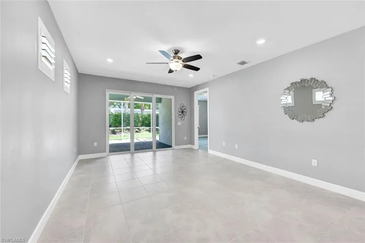 Empty room with ceiling fan and light tile patterned flooring