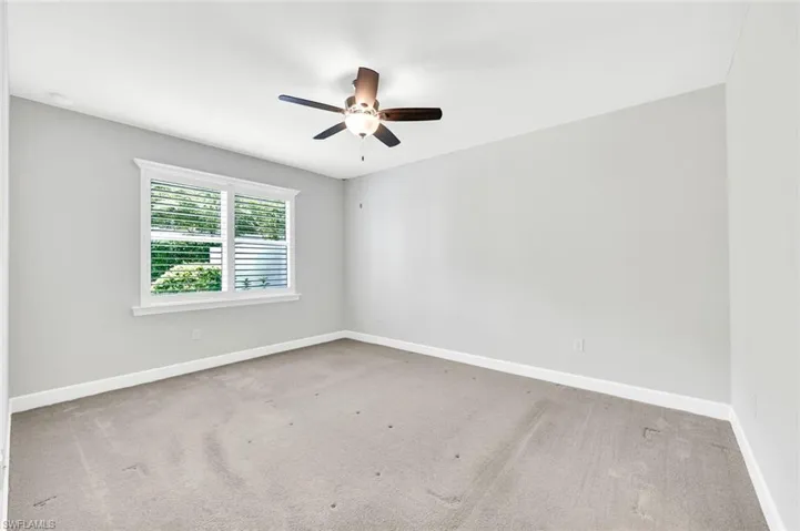 Carpeted empty room with ceiling fan
