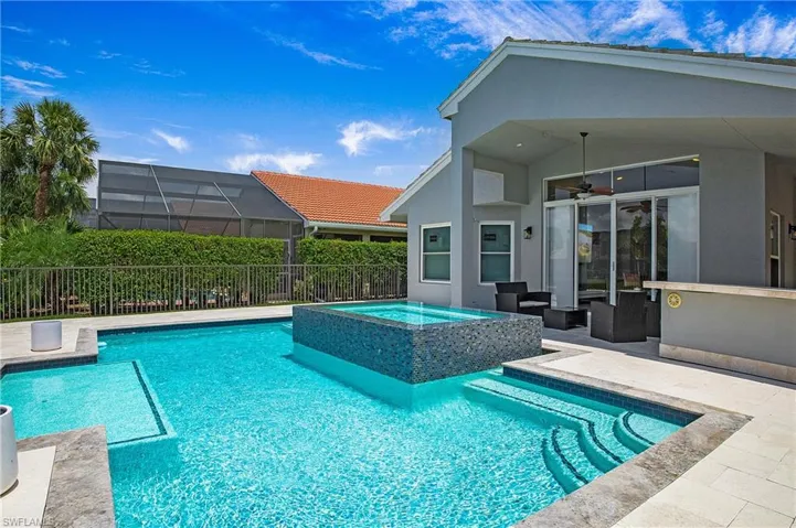 View of swimming pool with ceiling fan and an in ground hot tub
