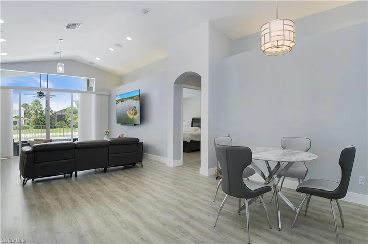 Dining space with light hardwood / wood-style floors and vaulted ceiling
