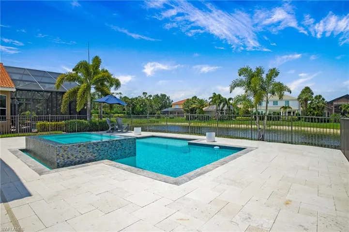 View of swimming pool with a patio area, a lanai, an in ground hot tub, and a water view