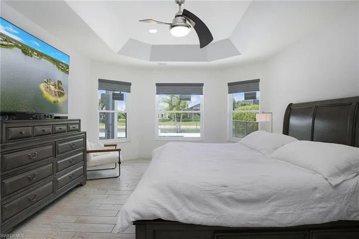 Bedroom featuring ceiling fan and a tray ceiling