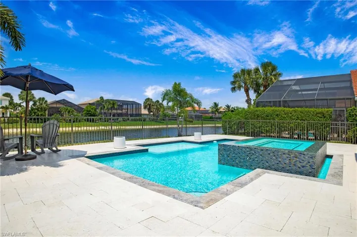 View of pool featuring an in ground hot tub, a water view, and a patio area