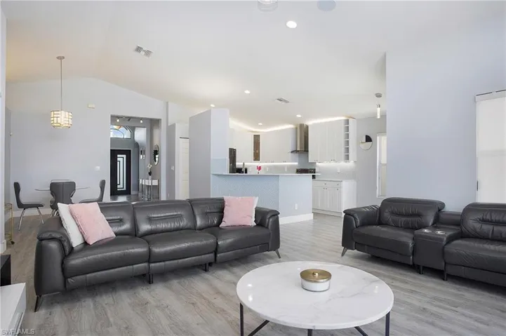 Living room featuring vaulted ceiling and light wood-type flooring