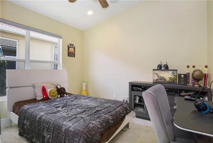 Bedroom with ceiling fan, light hardwood / wood-style flooring, and multiple windows