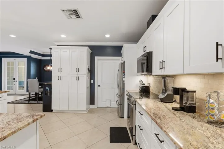 Open kitchen with island, granite counter tops, pantry, stainless steel appliances.