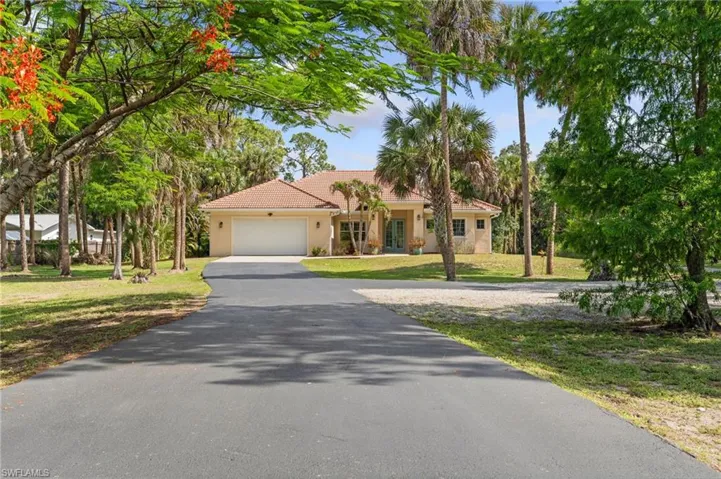 Curb appeal with home set back, paved driveway.