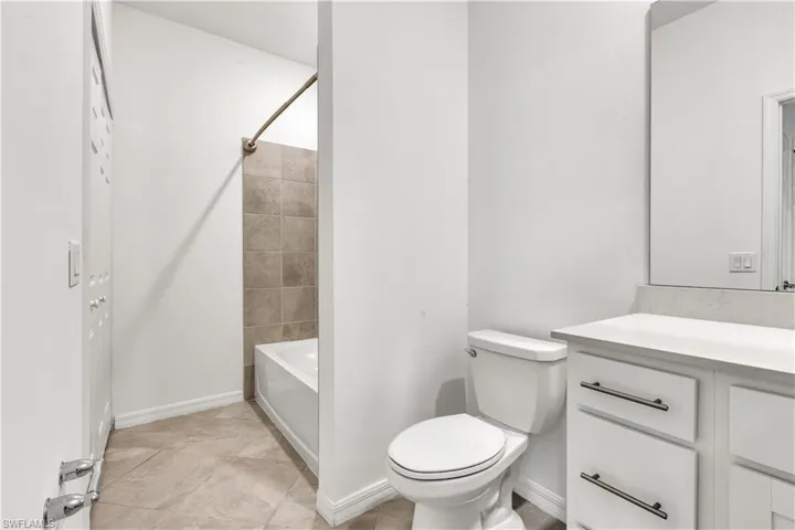 White vanity with contemporary bar pulls and a coordinating countertop