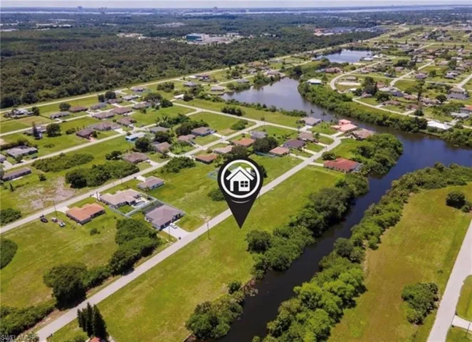 Aerial overview of property's location featuring a nearby body of water and nearby suburban area