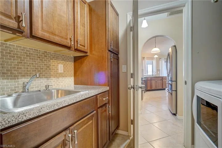 The laundry room with a large sink and tons of extra cabinet space