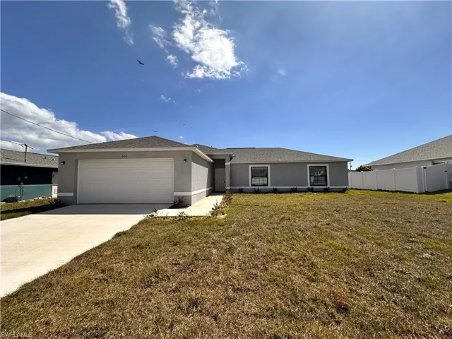 Single story home featuring fence, a front yard, stucco siding, driveway, and an attached garage