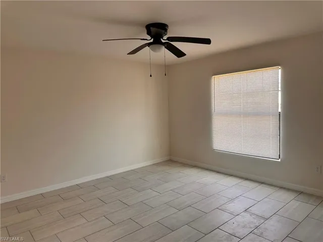 Unfurnished room featuring baseboards and ceiling fan
