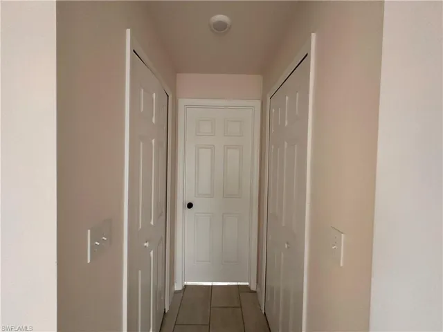 Hall featuring dark tile patterned flooring