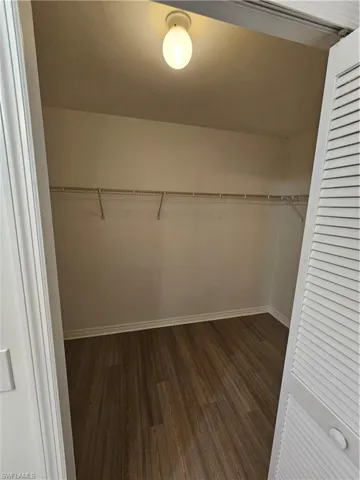 Interior closet featuring wood-finish flooring, white walls, and a built-in wire shelving system