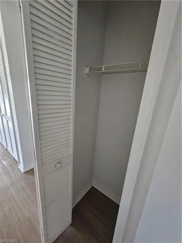Closet featuring louvered bi-fold doors, a wire shelving unit, and wood-finish flooring