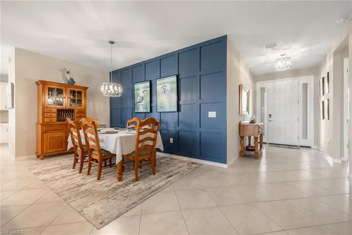 Dining space with light tile patterned floors and an inviting chandelier
