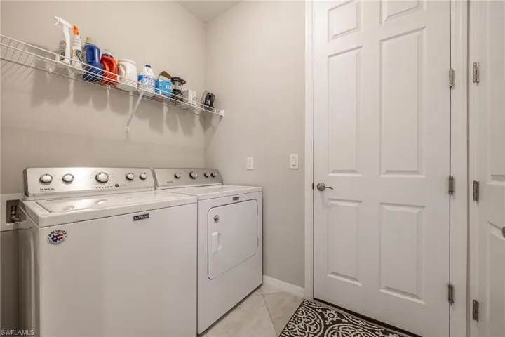 Laundry room featuring light tile patterned floors and independent washer and dryer