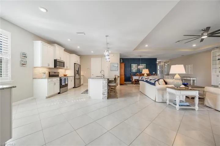 Tiled living room with ceiling fan and sink