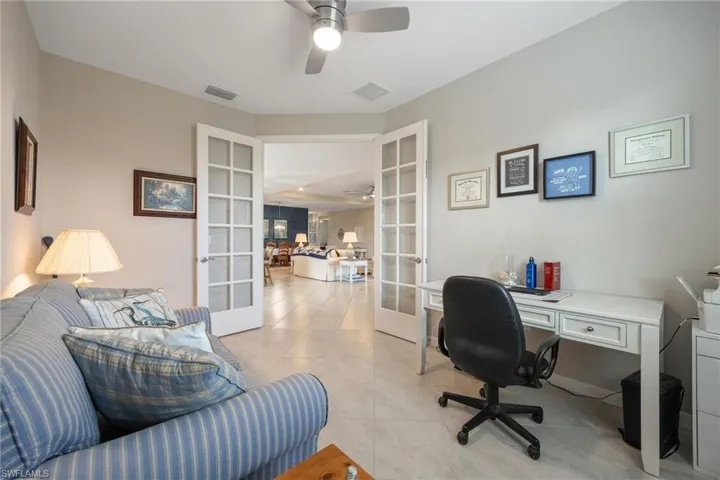 Tiled office with ceiling fan and french doors