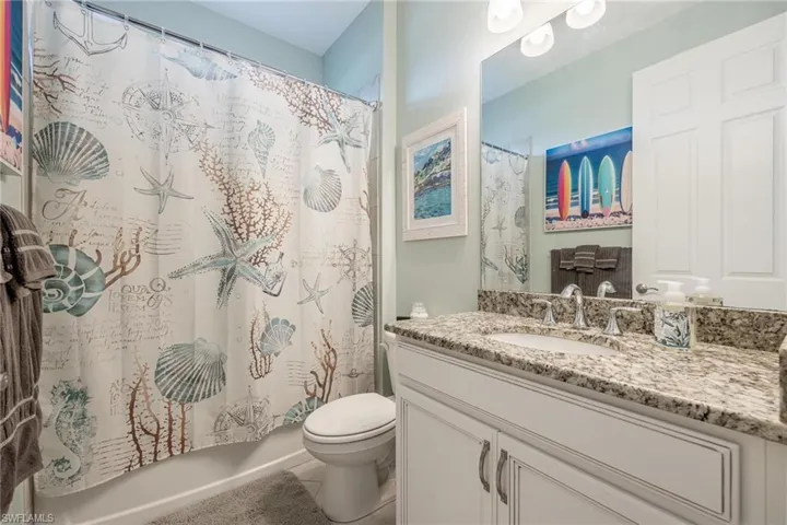 Full bathroom featuring tile patterned flooring, vanity, shower / bath combination with curtain, and toilet
