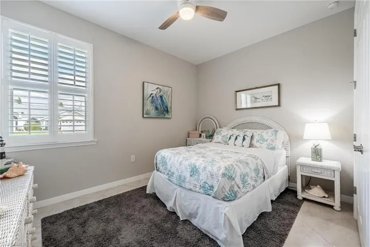 Bedroom with ceiling fan and light tile patterned flooring