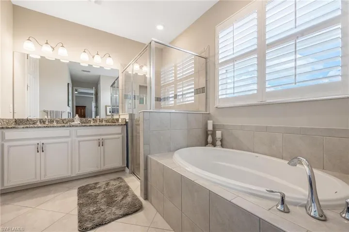 Bathroom featuring tile patterned flooring, vanity, and independent shower and bath