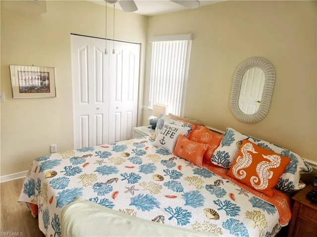 Bedroom with a closet, hardwood / wood-style floors, and ceiling fan