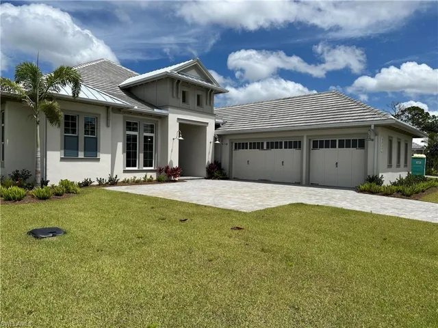 View of front of property featuring a garage and a front yard