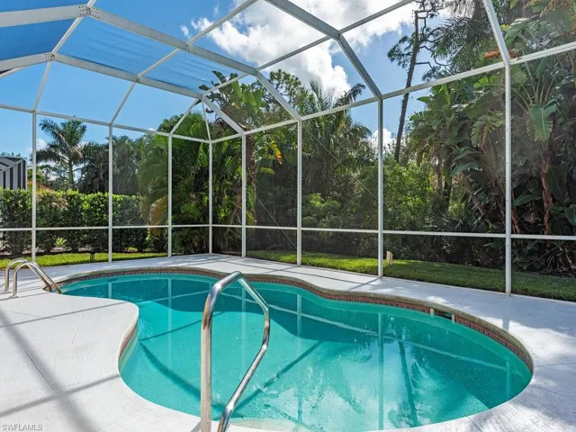 View of swimming pool with a patio and glass enclosure