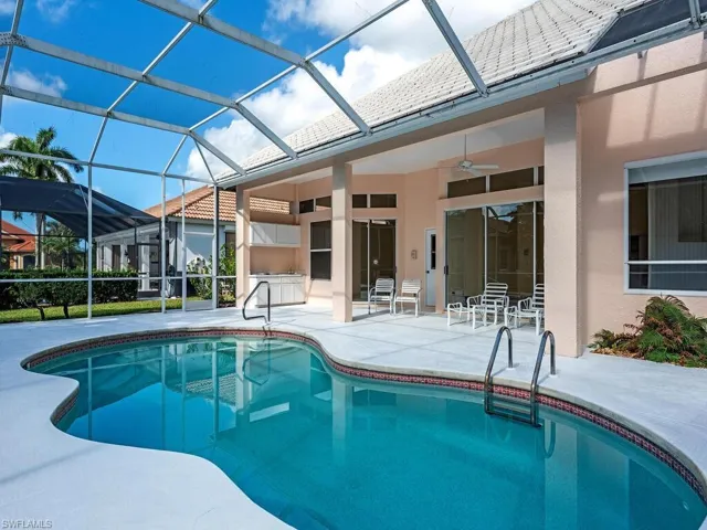 View of swimming pool featuring a patio, ceiling fan, and a lanai