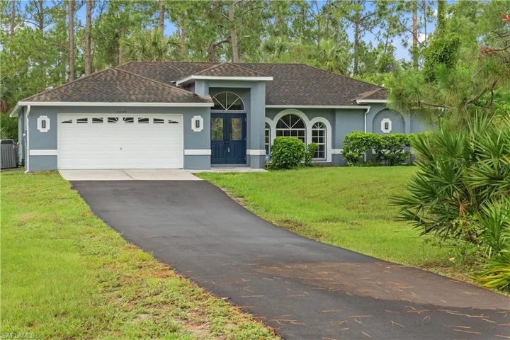 Ranch-style home with a garage, central AC, and a front lawn