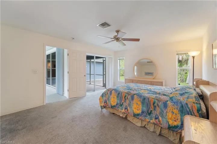 Carpeted bedroom featuring ceiling fan and access to exterior