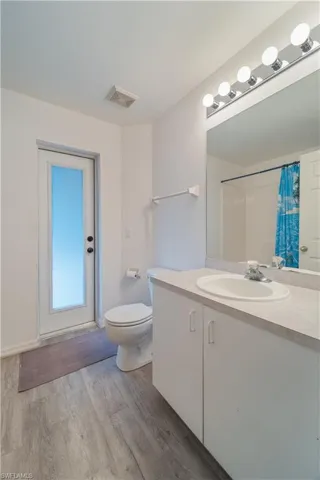 Bathroom with oversized vanity, hardwood / wood-style flooring, and toilet