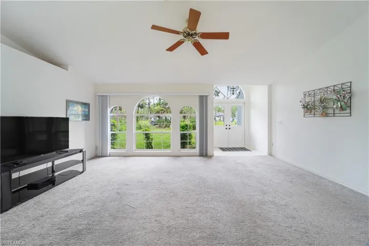 Unfurnished living room with a healthy amount of sunlight, carpet, and ceiling fan