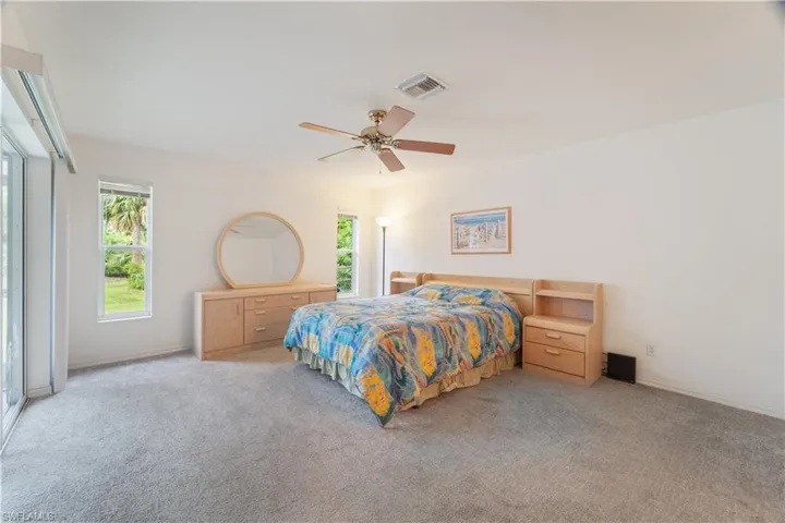 Bedroom with ceiling fan and light carpet