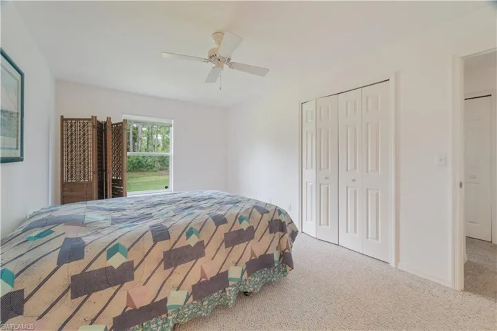 Carpeted bedroom featuring ceiling fan