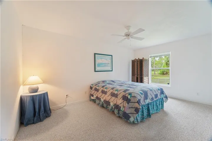 Carpeted bedroom featuring ceiling fan