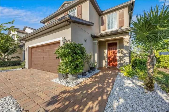View of front of home featuring a garage, stucco siding, and decorative driveway