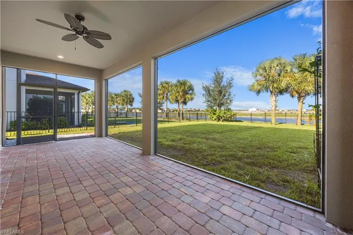 Unfurnished sunroom with a ceiling fan and a water view