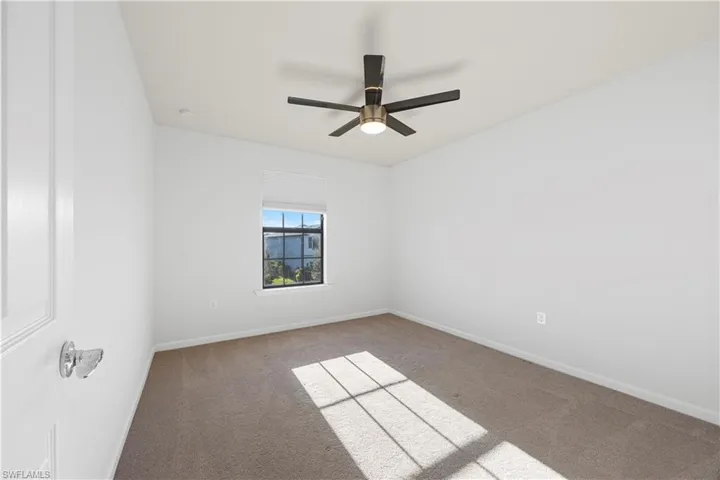 Empty room with carpet flooring and ceiling fan