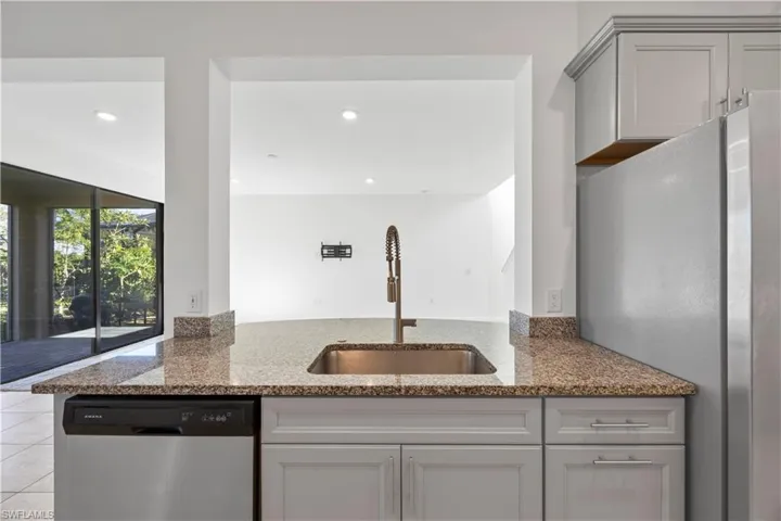Kitchen featuring stainless steel appliances, dark stone counters, recessed lighting, gray cabinets, and tile patterned floors