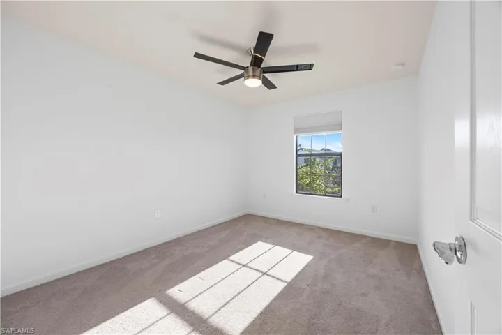 Spare room with carpet and ceiling fan
