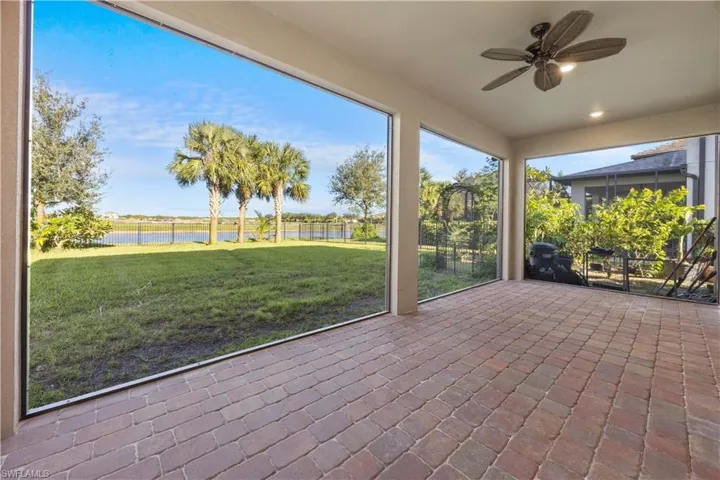 Unfurnished sunroom featuring a ceiling fan, a water view, and healthy amount of natural light