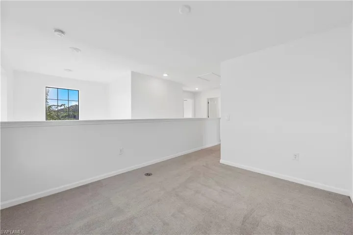Unfurnished room with light colored carpet and recessed lighting