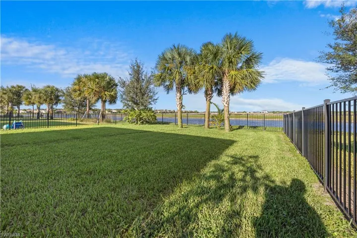 Fenced backyard featuring a water view
